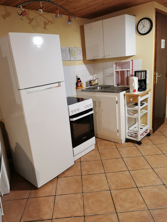 14 - Espace cuisine : réfrigérateur congélateur, gazinière vitrocéramique, évier, placards